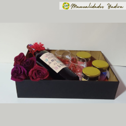 Caja de vino con tres variedades de frutos secos y flores decorativas, perfecta para un regalo especial.